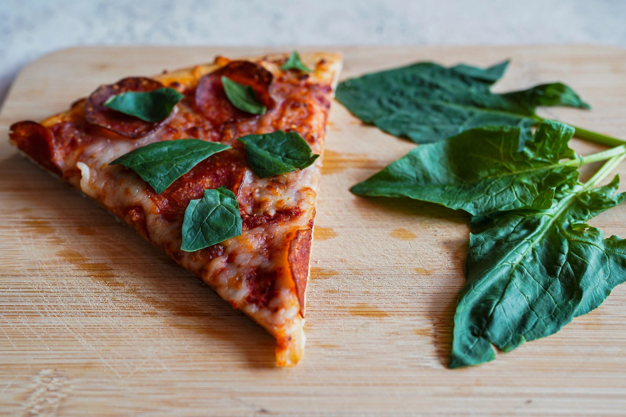 Fresh pizza slice with spinach and pepperoni used as visual accent for guest quote